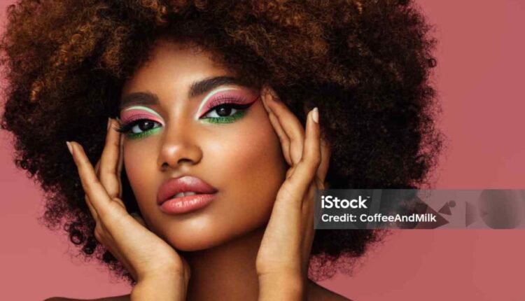 Portrait d’une jeune femme afro au maquillage lumineux